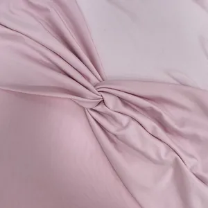 Détail des coutures en mesh et du nœud sur la robe moulante rose à dos nu
