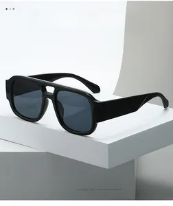 Detail view of fashion oversized double bridge sunglasses on a white minimalist platform