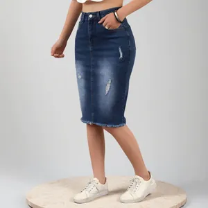 Dettaglio della gonna di jeans blu scuro lavato con strappi e bordo dell'orlo sfrangiato