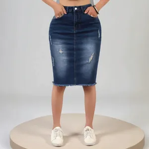 Dettaglio della gonna midi in denim con strappi usurati e orlo sfrangiato a taglio vivo