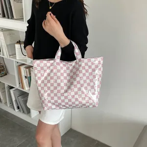 Detail of pink and white checkered tote bag in glossy finish with TOTE BAG print
