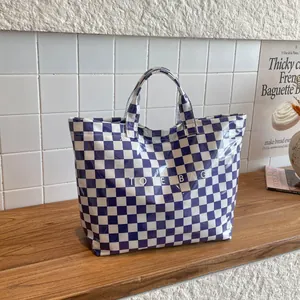 Blue and white checkered waterproof tote bag with shiny finish and printed lettering
