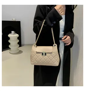 Gros plan du sac matelassé beige avec chaîne et fermoir métallique élégant