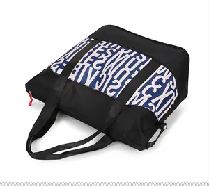 Flat lay view of a large capacity tote bag with blue and white letter print and zipper