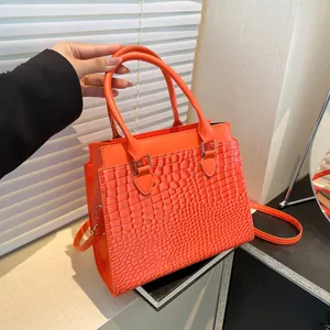 Vibrant orange crocodile embossed leather tote bag with top handles and shoulder strap