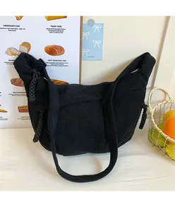 Close-up of black corduroy dumpling bag showing striped texture and woven drawstring detail