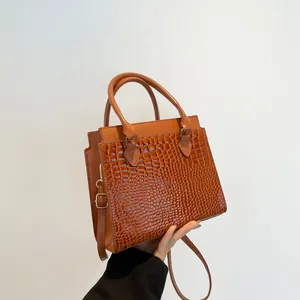 Caramel brown croc-embossed tote bag with structured top handles and shoulder strap
