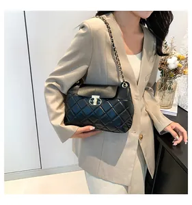 Détail du sac matelassé noir avec élégant fermoir rotatif ovale en métal doré