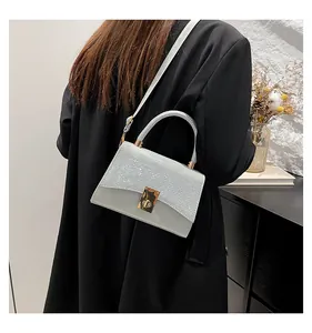 Detail of glitter patchwork mini crossbody bag with golden metal turn-lock closure