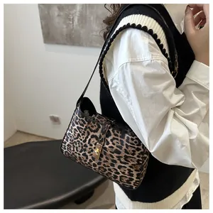 Détail du sac croissant à motif léopard avec fermoir en métal doré et fine bandoulière