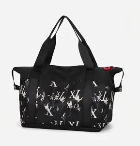 Detail view of large black travel tote showing floral pattern and side snap button closure