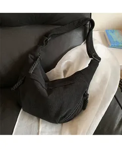 Detail of black corduroy dumpling bag showing ribbed texture and adjustable strap