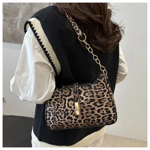 Close-up of leopard print shoulder bag with gold chain strap and metal clasp detail