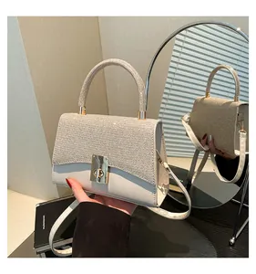 Close-up of elegant cream leather handbag with sparkling glitter flap and gold metal lock