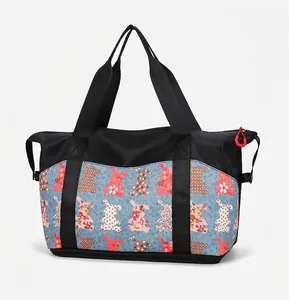 Detailed side view of large travel tote with floral rabbit pattern and red zipper pull
