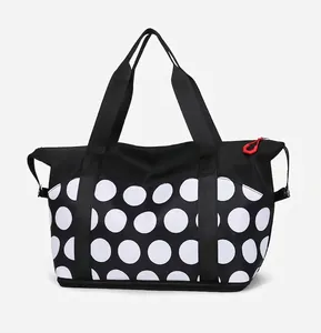 Side view of large polka dot travel tote featuring durable black webbing handles