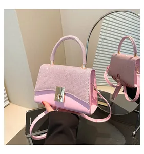 Detailed close-up of pink sequin handbag with gold twist lock and crossbody strap
