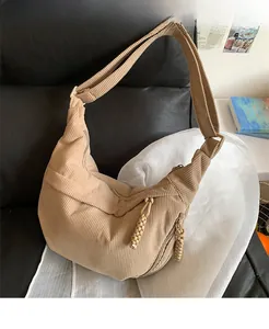 Detailed texture of khaki corduroy fabric on a large crescent shaped crossbody bag