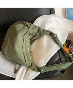 Detail of the green corduroy crescent crossbody bag featuring striped texture and strap