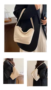 Detalle del bolso de hombro de nailon beige con material texturizado y cierre de cremallera