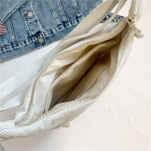 Off-white corduroy hobo bag with spacious interior compartments and smooth zipper closure