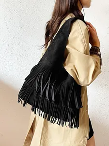 Retro zwarte suède draagtas met franjes in een minimalistische bohemien stijl