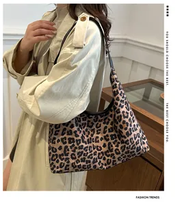 Detail van een trendy schoudertas met luipaardprint en zwarte riem op een vrouwelijk model