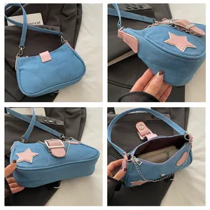 Dettaglio borsa hobo in denim blu con stelle rosa e decorazione con catena metallica