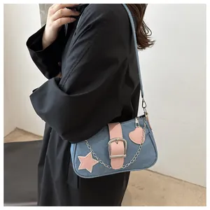 Dettaglio borsa a spalla in denim con stelle in pelle rosa e catena argento