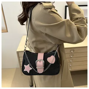 Dettaglio borsa a spalla in denim con toppe a cuore rosa e catena in argento chic