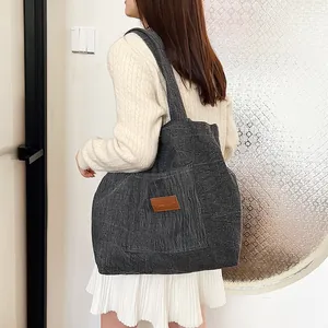 Grand sac cabas gris foncé en velours côtelé avec poche avant et logo en cuir chic
