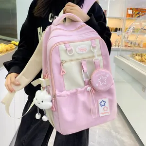 Pink and beige school backpack detail showing the mini bag charm and cloud plush pendant