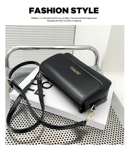 Detail of black faux leather bag with gold JINGPINPIJU lettering and slim shoulder strap