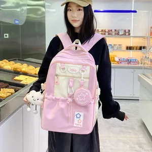 Detailed view of pink and beige backpack with cloud charm and mini bag in a bakery setting