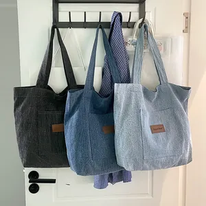 Trois grands sacs cabas en denim en noir, bleu foncé et bleu clair avec bandoulières