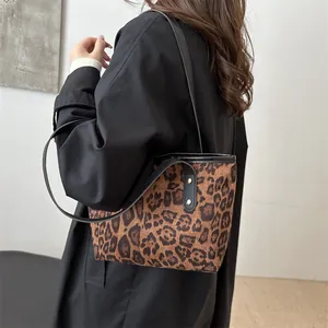 Detailed view of leopard print tote bag texture with black strap and golden studs