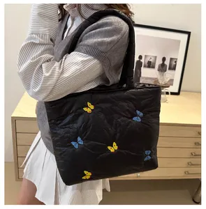 Détail du sac cabas matelassé noir avec motifs de broderie de papillons colorés