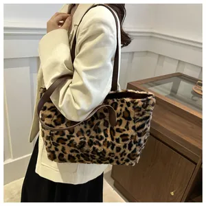 Detailed view of leopard print plush tote bag with slim brown leather straps on a model