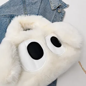 Close-up of white plush puppy bag with big eye embroidery and gold chain strap