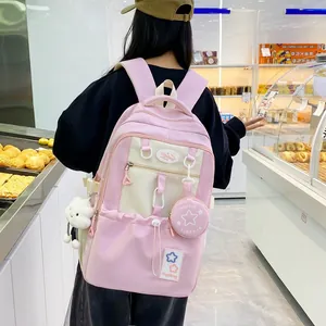 Detail showing pink and white student backpack with cute cloud and mini bag charms