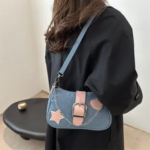 Borsa a spalla Y2K in denim con stelle rosa e catena d'argento indossata da modella