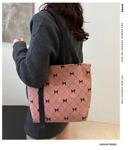 Details der rosa Cord-Tragetasche mit schwarzen Schleifen und gestepptem Muster