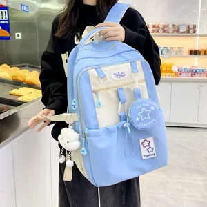 Detail of light blue and beige backpack with star mini bag and cloud pendant
