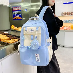 Detail of blue and beige school backpack with a star coin purse charm in a cafe setting