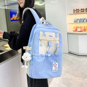 Detail of light blue and beige school backpack with cloud plush charm and mini bag