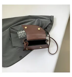 Detailed top view of a brown faux crocodile leather saddle bag with magnetic gold buckle