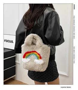 Detail of soft plush handbag with colorful rainbow patch and delicate metal chain strap