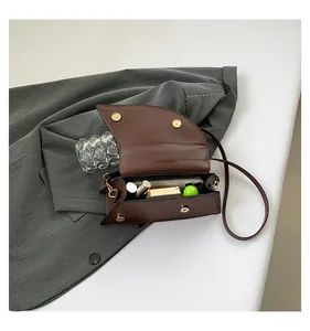 Interior view of brown faux leather saddle bag showing storage capacity for phone and cosmetics