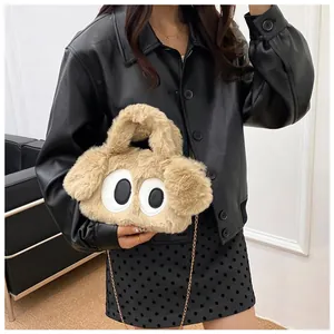 Gros plan du sac chiot pelucheux avec grands yeux de dessin animé et chaîne dorée