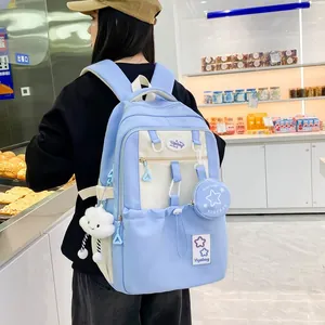 Detail of light blue school backpack with cloud plush charm in a lifestyle store setting